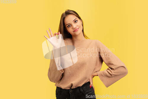 Image of Portrait of young caucasian woman with bright emotions isolated on yellow studio background