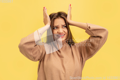 Image of Portrait of young caucasian woman with bright emotions isolated on yellow studio background