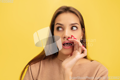 Image of Portrait of young caucasian woman with bright emotions isolated on yellow studio background