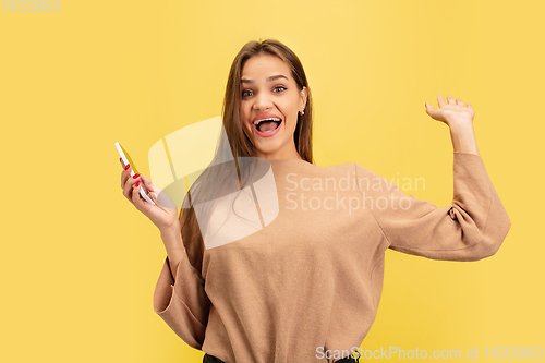 Image of Portrait of young caucasian woman with bright emotions isolated on yellow studio background