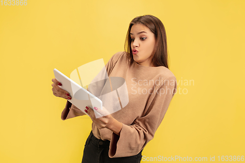 Image of Portrait of young caucasian woman with bright emotions isolated on yellow studio background