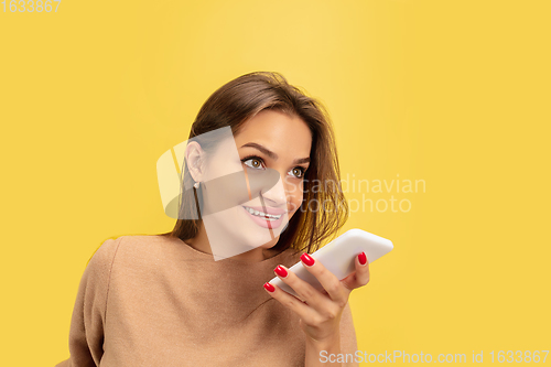 Image of Portrait of young caucasian woman with bright emotions isolated on yellow studio background