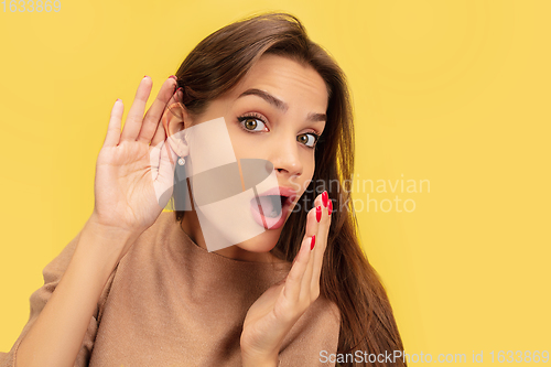 Image of Portrait of young caucasian woman with bright emotions isolated on yellow studio background