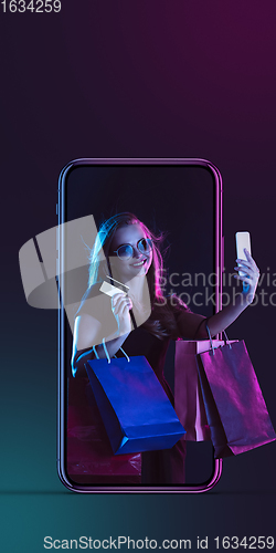 Image of Beautiful woman inviting for shopping right from device screen, black friday, sales concept. Flyer with copyspace