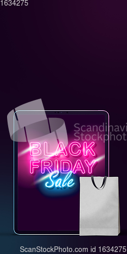 Image of Device with shopping bags, black friday, sales concept. Flyer with copyspace. Dark neoned background