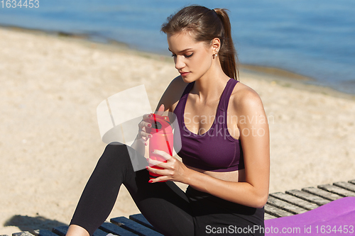 Image of Young woman training outdoors in autumn sunshine. Concept of sport, healthy lifestyle, movement, activity.