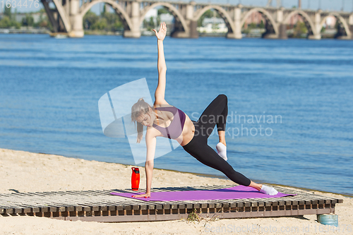 Image of Young woman training outdoors in autumn sunshine. Concept of sport, healthy lifestyle, movement, activity.