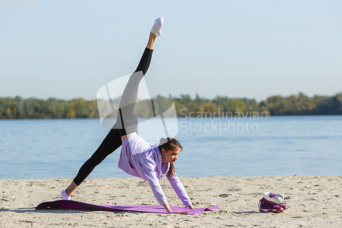 Image of Young woman training outdoors in autumn sunshine. Concept of sport, healthy lifestyle, movement, activity.