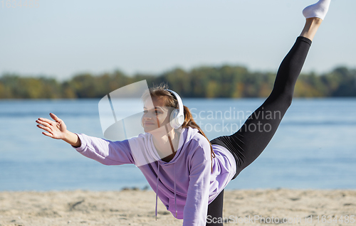 Image of Young woman training outdoors in autumn sunshine. Concept of sport, healthy lifestyle, movement, activity.