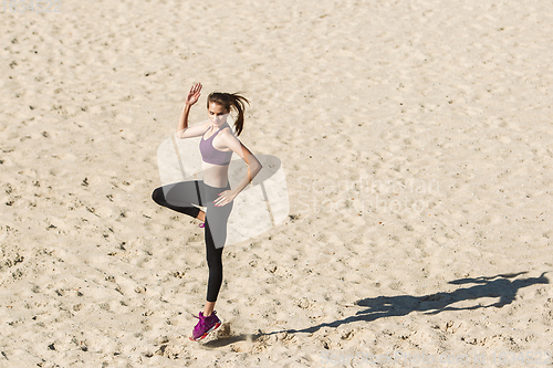 Image of Young woman training outdoors in autumn sunshine. Concept of sport, healthy lifestyle, movement, activity.