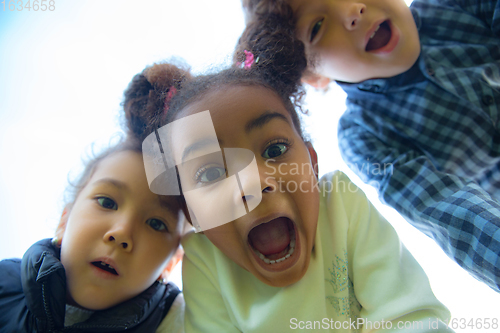 Image of Interracial group of kids, girls and boys playing together at the park in summer day