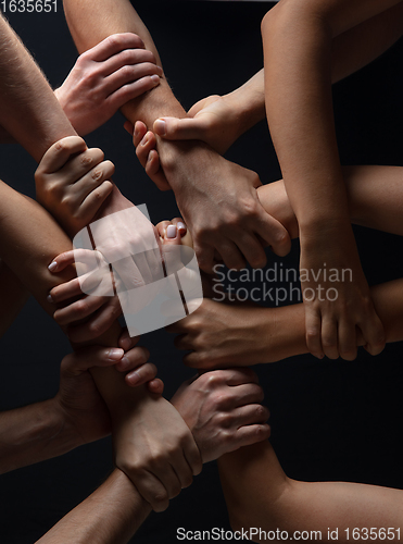 Image of Hands of people\'s crowd in touch isolated on black studio background. Concept of human relation, community, togetherness, symbolism