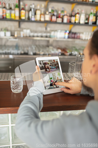 Image of Remote working. Workplace in bar, restaurant office with PC, devices and gadgets.