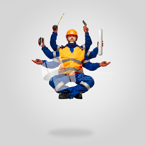 Image of Handsome contractor, multi-armed builder levitating isolated on grey studio background