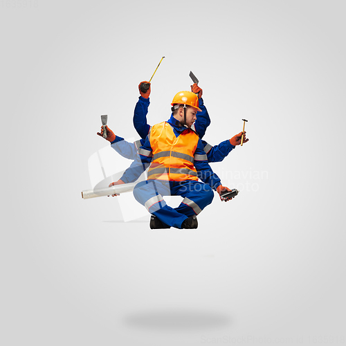 Image of Handsome contractor, multi-armed builder levitating isolated on grey studio background