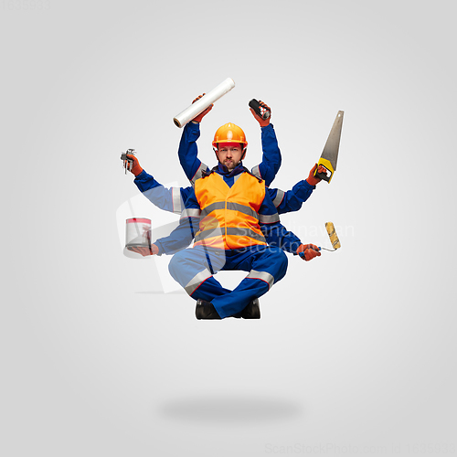 Image of Handsome contractor, multi-armed builder levitating isolated on grey studio background