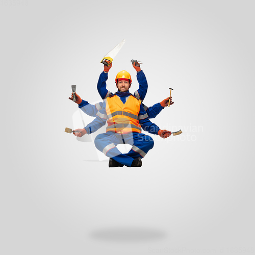 Image of Handsome contractor, multi-armed builder levitating isolated on grey studio background