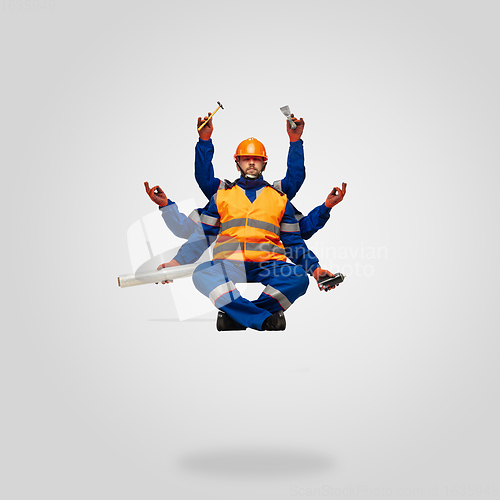 Image of Handsome contractor, multi-armed builder levitating isolated on grey studio background