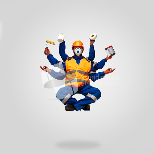 Image of Handsome contractor, multi-armed builder levitating isolated on grey studio background