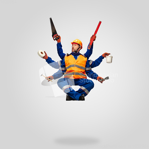 Image of Handsome contractor, multi-armed builder levitating isolated on grey studio background