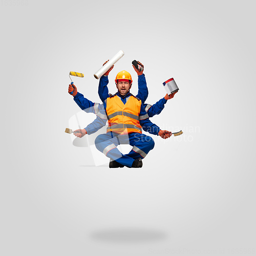 Image of Handsome contractor, multi-armed builder levitating isolated on grey studio background