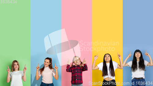 Image of Young people pointing up smiling on multicolored background. Human emotions, facial expression concept. Trendy colors. Creative collage.