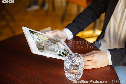 Image of Remote working. Workplace in bar, restaurant office with PC, devices and gadgets.