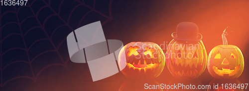 Image of Scary pumpkins on dark orange background, the night of fear