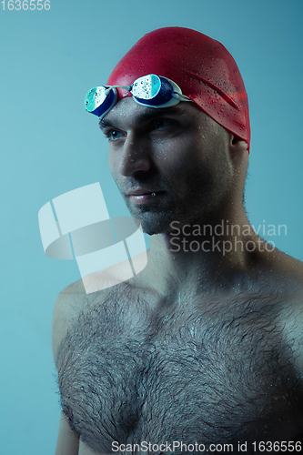 Image of Professional male swimmer with hat and goggles in motion and action, healthy lifestyle and movement concept. Neoned style.
