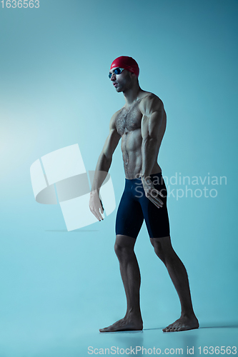 Image of Professional male swimmer with hat and goggles in motion and action, healthy lifestyle and movement concept. Neoned style.
