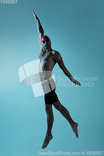 Image of Professional male swimmer with hat and goggles in motion and action, healthy lifestyle and movement concept. Neoned style.
