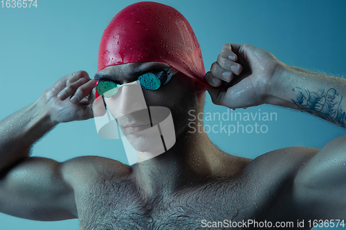 Image of Professional male swimmer with hat and goggles in motion and action, healthy lifestyle and movement concept. Neoned style.