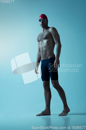 Image of Professional male swimmer with hat and goggles in motion and action, healthy lifestyle and movement concept. Neoned style.