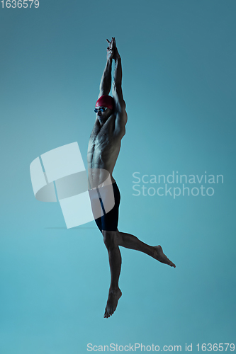 Image of Professional male swimmer with hat and goggles in motion and action, healthy lifestyle and movement concept. Neoned style.
