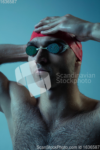 Image of Professional male swimmer with hat and goggles in motion and action, healthy lifestyle and movement concept. Neoned style.