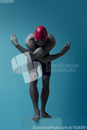 Image of Professional male swimmer with hat and goggles in motion and action, healthy lifestyle and movement concept. Neoned style.