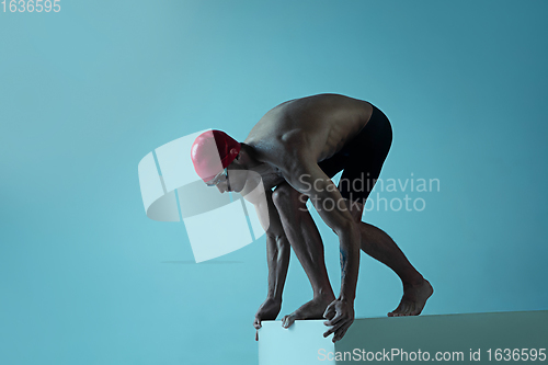 Image of Professional male swimmer with hat and goggles in motion and action, healthy lifestyle and movement concept. Neoned style.