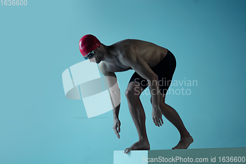 Image of Professional male swimmer with hat and goggles in motion and action, healthy lifestyle and movement concept. Neoned style.