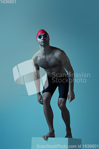 Image of Professional male swimmer with hat and goggles in motion and action, healthy lifestyle and movement concept. Neoned style.