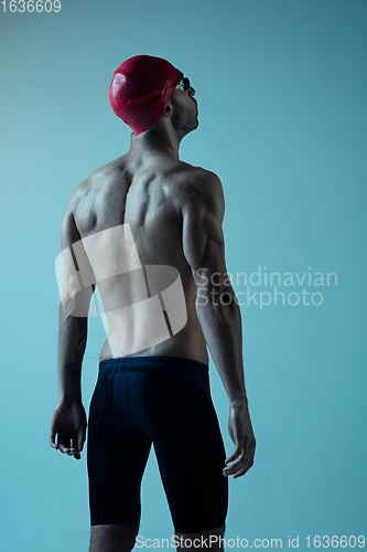 Image of Professional male swimmer with hat and goggles in motion and action, healthy lifestyle and movement concept. Neoned style.