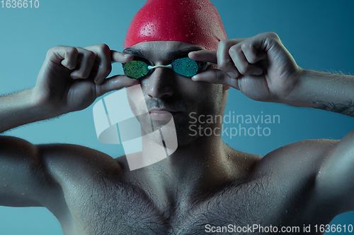 Image of Professional male swimmer with hat and goggles in motion and action, healthy lifestyle and movement concept. Neoned style.