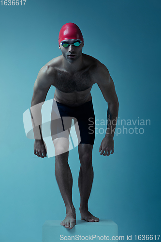 Image of Professional male swimmer with hat and goggles in motion and action, healthy lifestyle and movement concept. Neoned style.