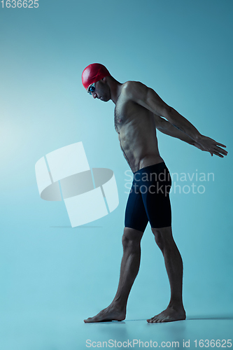 Image of Professional male swimmer with hat and goggles in motion and action, healthy lifestyle and movement concept. Neoned style.