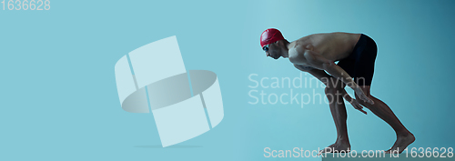 Image of Professional male swimmer with hat and goggles in motion and action, healthy lifestyle and movement concept. Neoned style.