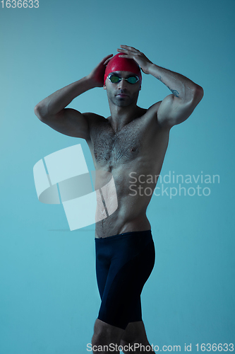 Image of Professional male swimmer with hat and goggles in motion and action, healthy lifestyle and movement concept. Neoned style.