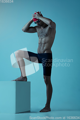 Image of Professional male swimmer with hat and goggles in motion and action, healthy lifestyle and movement concept. Neoned style.