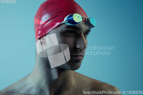 Image of Professional male swimmer with hat and goggles in motion and action, healthy lifestyle and movement concept. Neoned style.