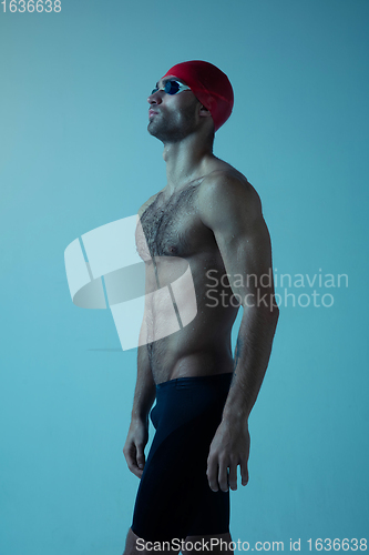 Image of Professional male swimmer with hat and goggles in motion and action, healthy lifestyle and movement concept. Neoned style.