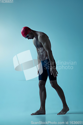 Image of Professional male swimmer with hat and goggles in motion and action, healthy lifestyle and movement concept. Neoned style.