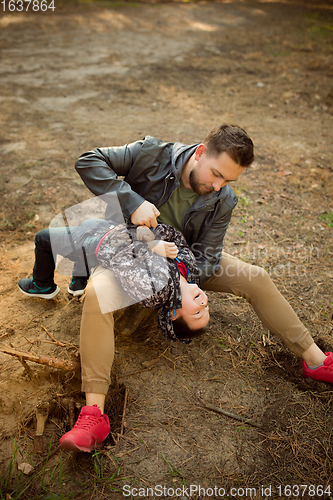 Image of Father and son walking and having fun in autumn forest, look happy and sincere